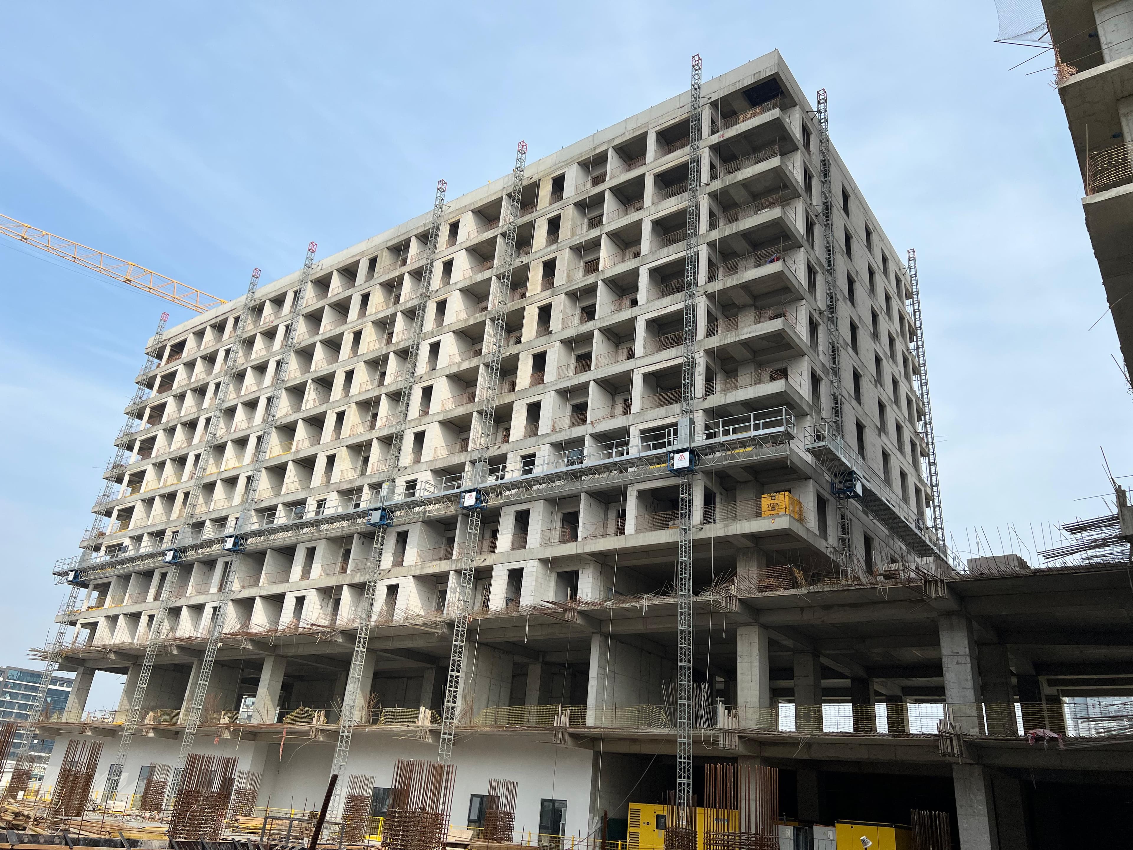 Multiple ALPMAKSAN mast climbing work platforms installed across the facade of a high-rise concrete building under construction in Bursa