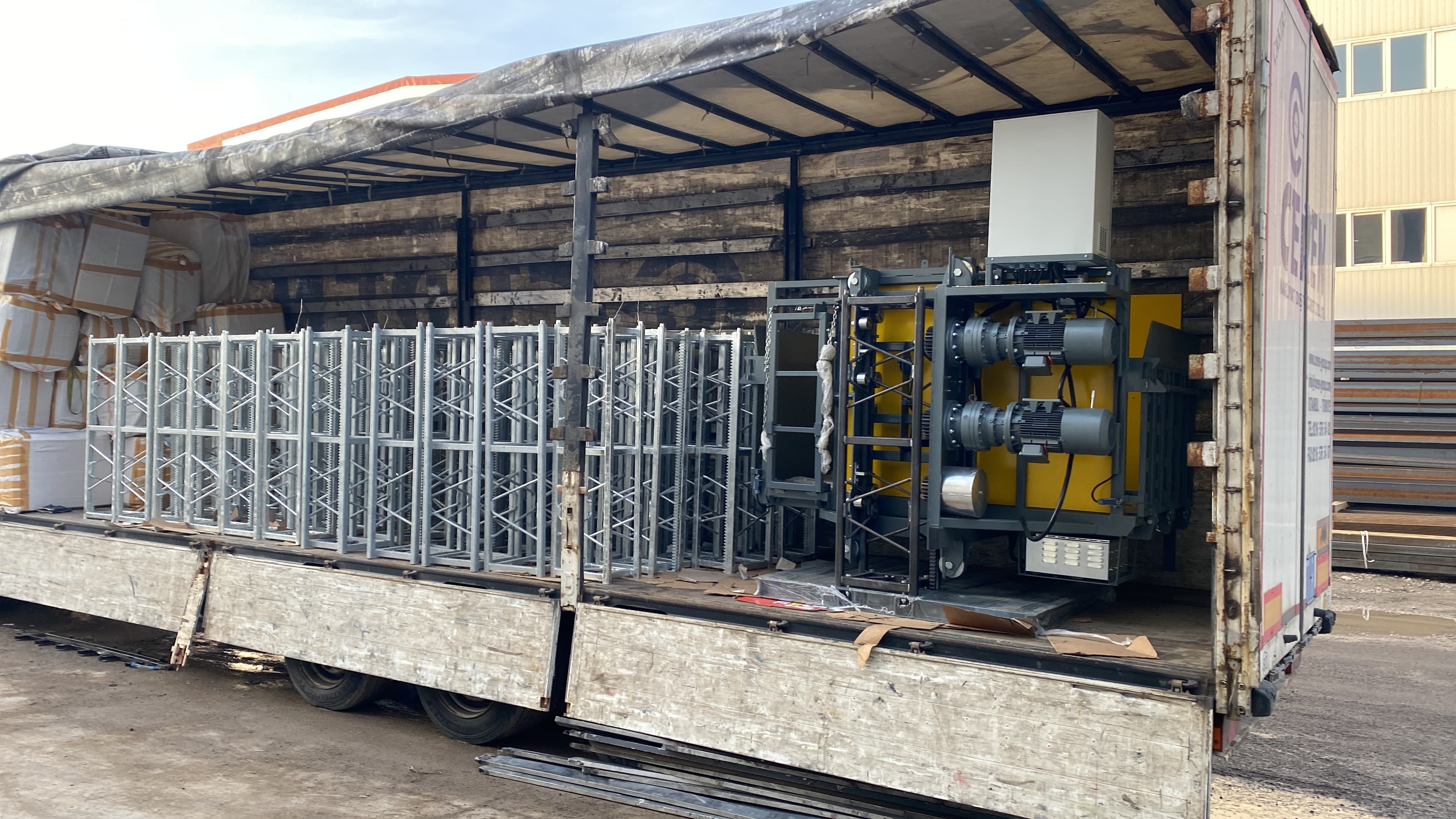 Close view of mast sections and a yellow drive unit secured inside a freight trailer