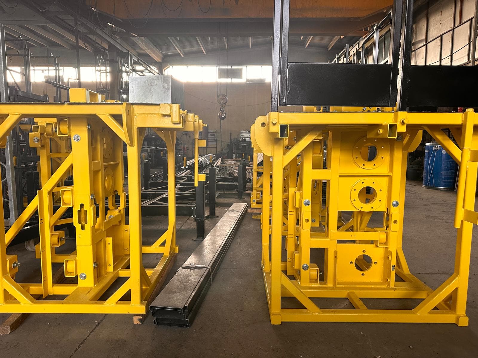 Yellow-painted steel drive frames prepared for assembly on the factory floor