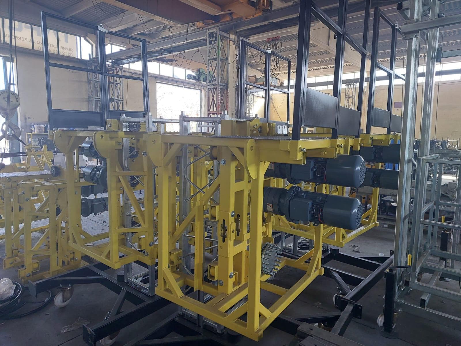 Yellow ALPMAKSAN drive units with dual electric motors during mechanical assembly